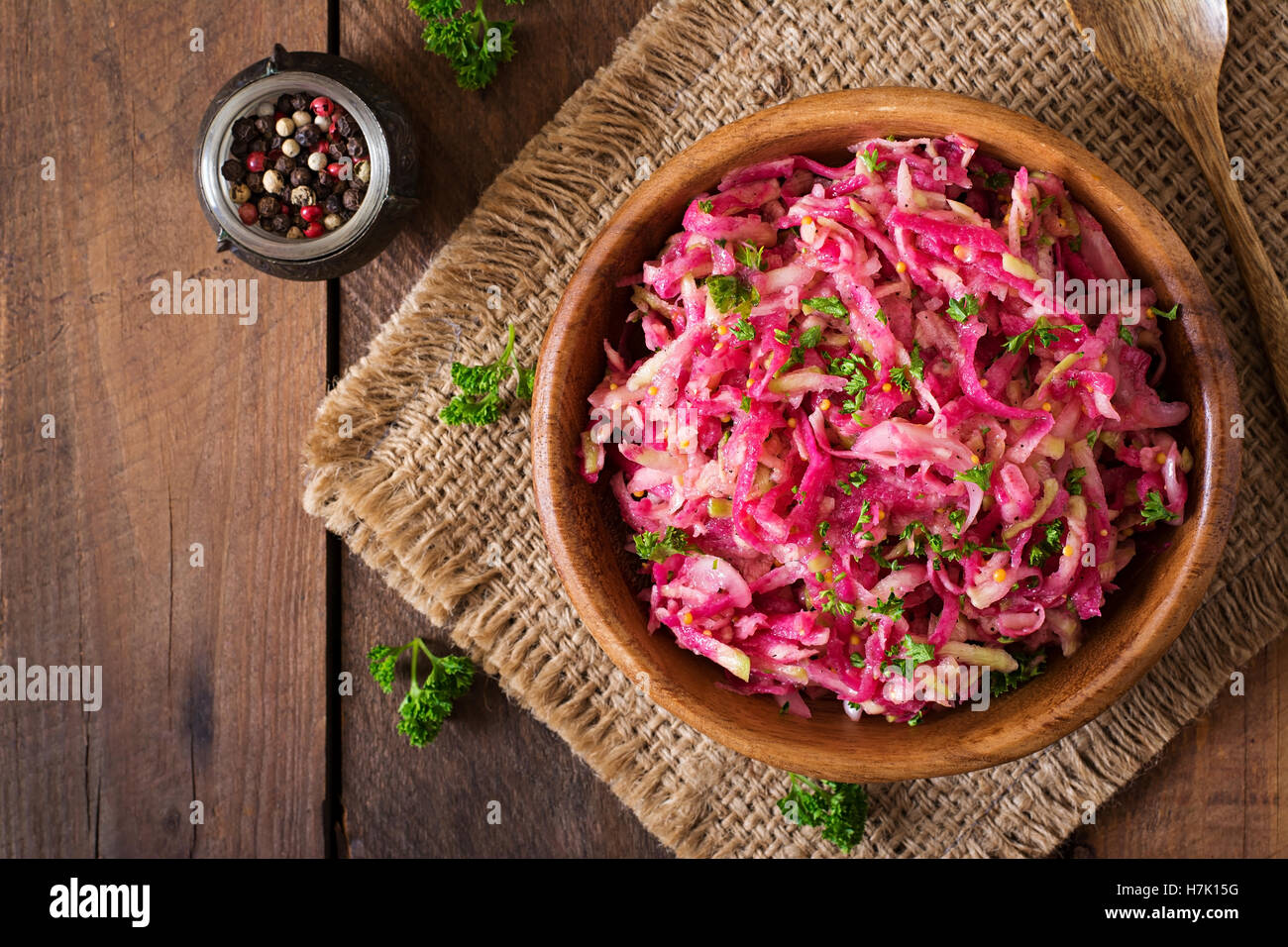 Pink daikon salad with apples, pickled onions and parsley. Top view Stock Photo