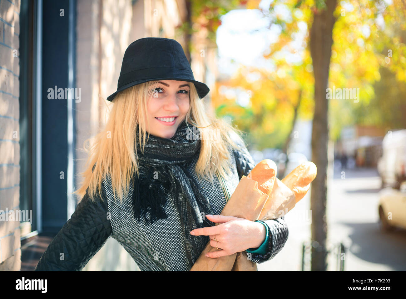 Young beautiful woman with a loaf of bread in her hands in autumn. Outdoors portrait. Stock Photo