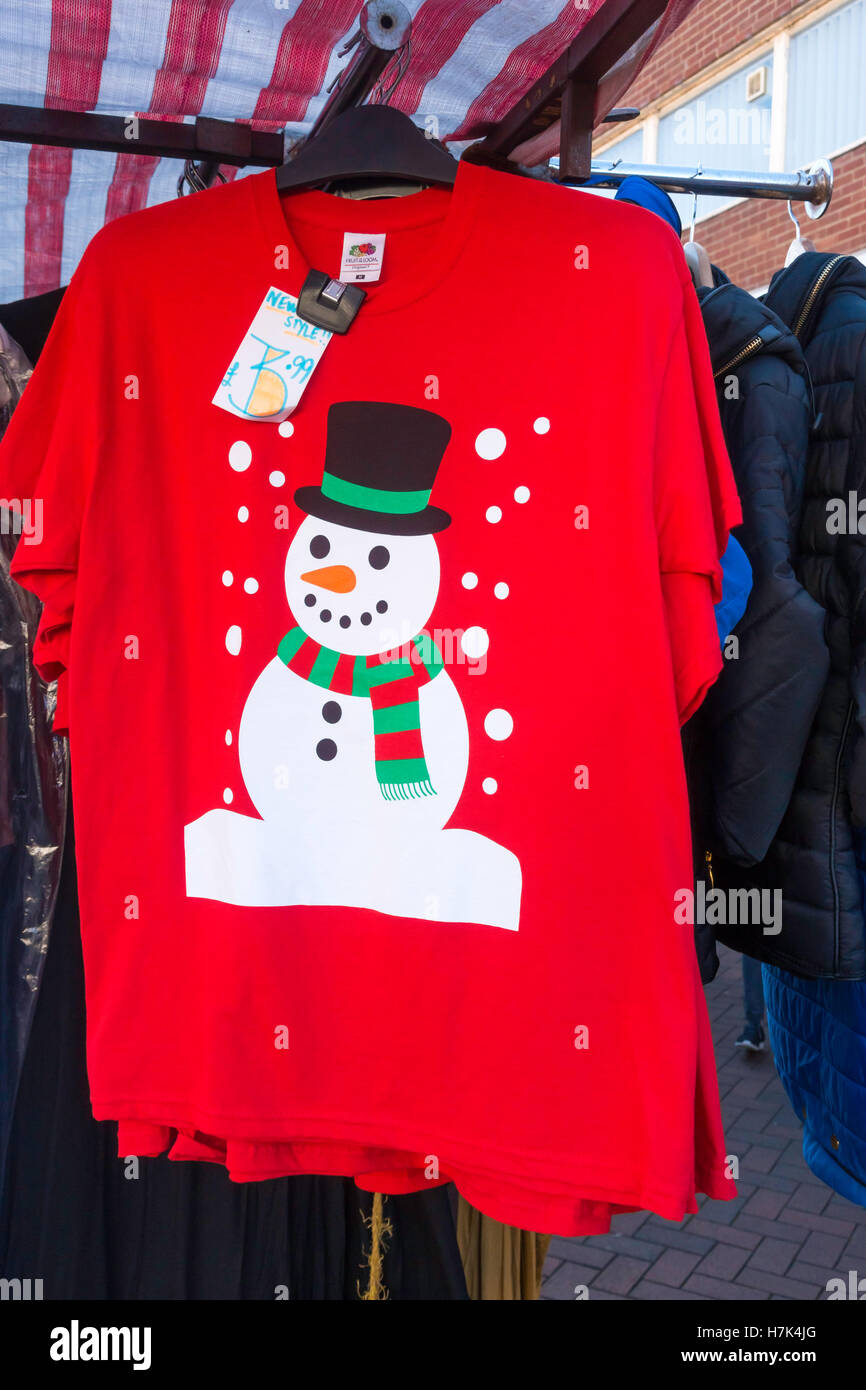 Market stall Christmas novelty sale-red T shirt with a printed Snow Man  pattern Stock Photo