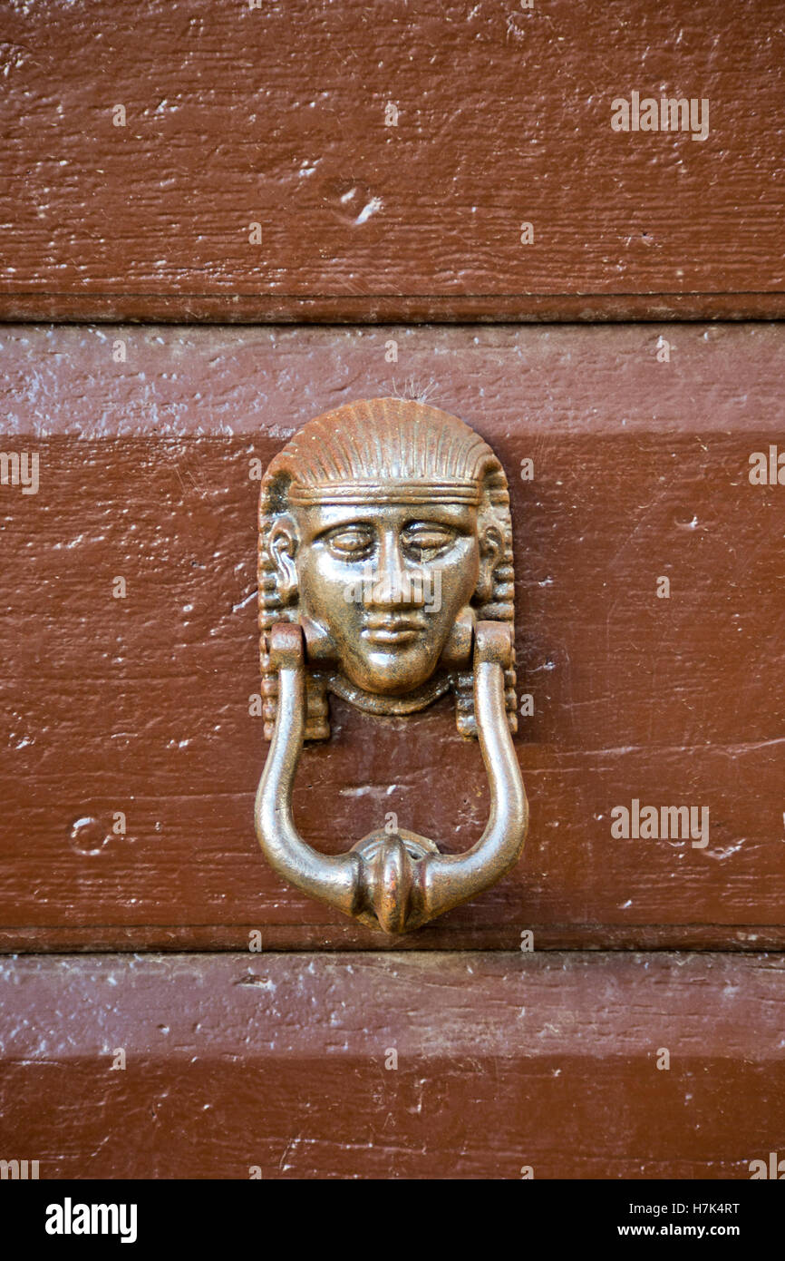 knocker head of antique metal egypt pharaoh of old wooden door Stock