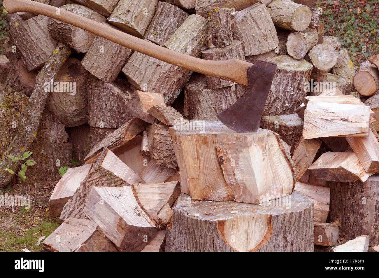 Axe and woodpile for domestic heating, showing split logs, Norfolk, UK, October Stock Photo