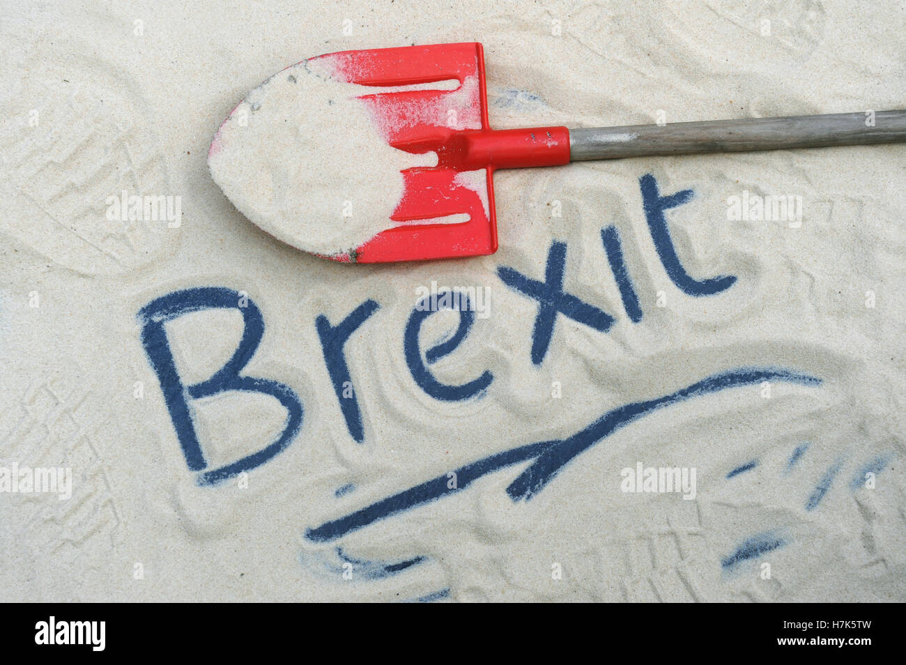 BREXIT WORD WRITTEN IN SAND WITH RED SPADE RE BREXIT THE EUROPEAN UNION REFERENDUM EU LEAVING INVOKE ARTICLE 50 UK Stock Photo