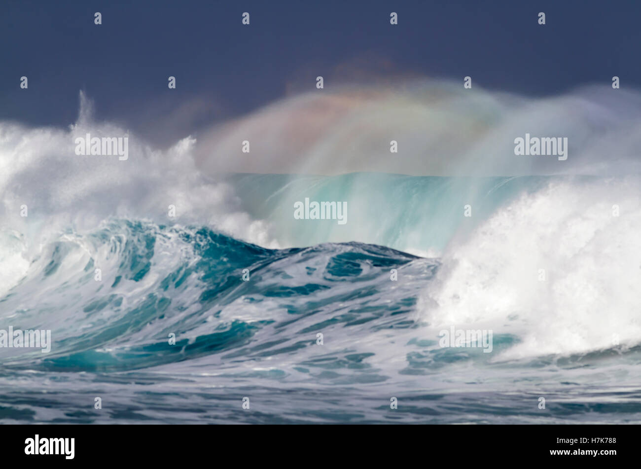 Rainbow colors light up the spray of a beautiful Ocean wave on the ...