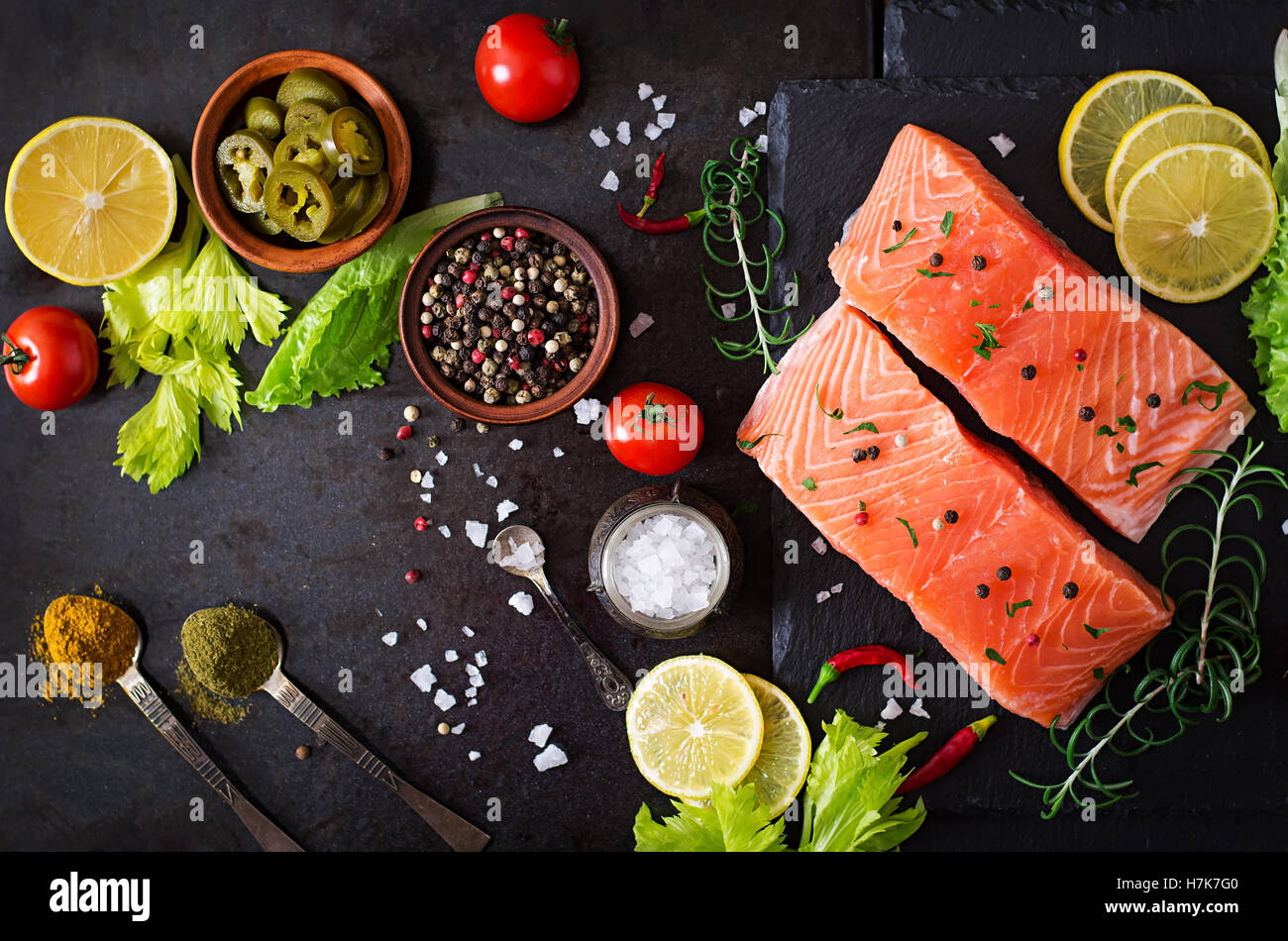 Raw salmon fillet and ingredients for cooking on a dark background in a ...