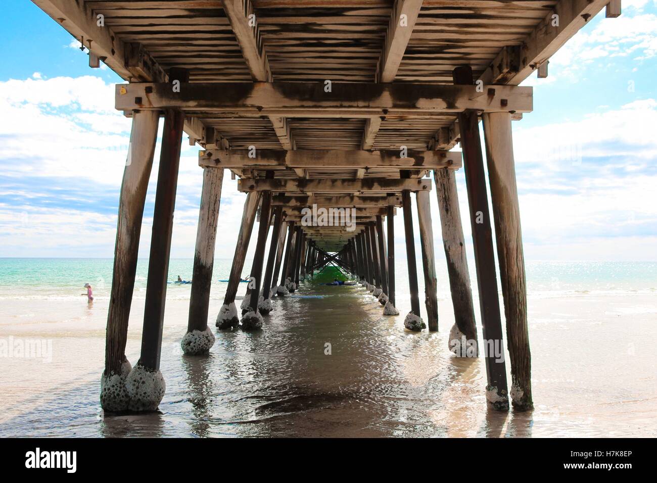 One-point perspective shot taken underneath a wooden jetty / pier on a beach in South Australia. Stock Photo