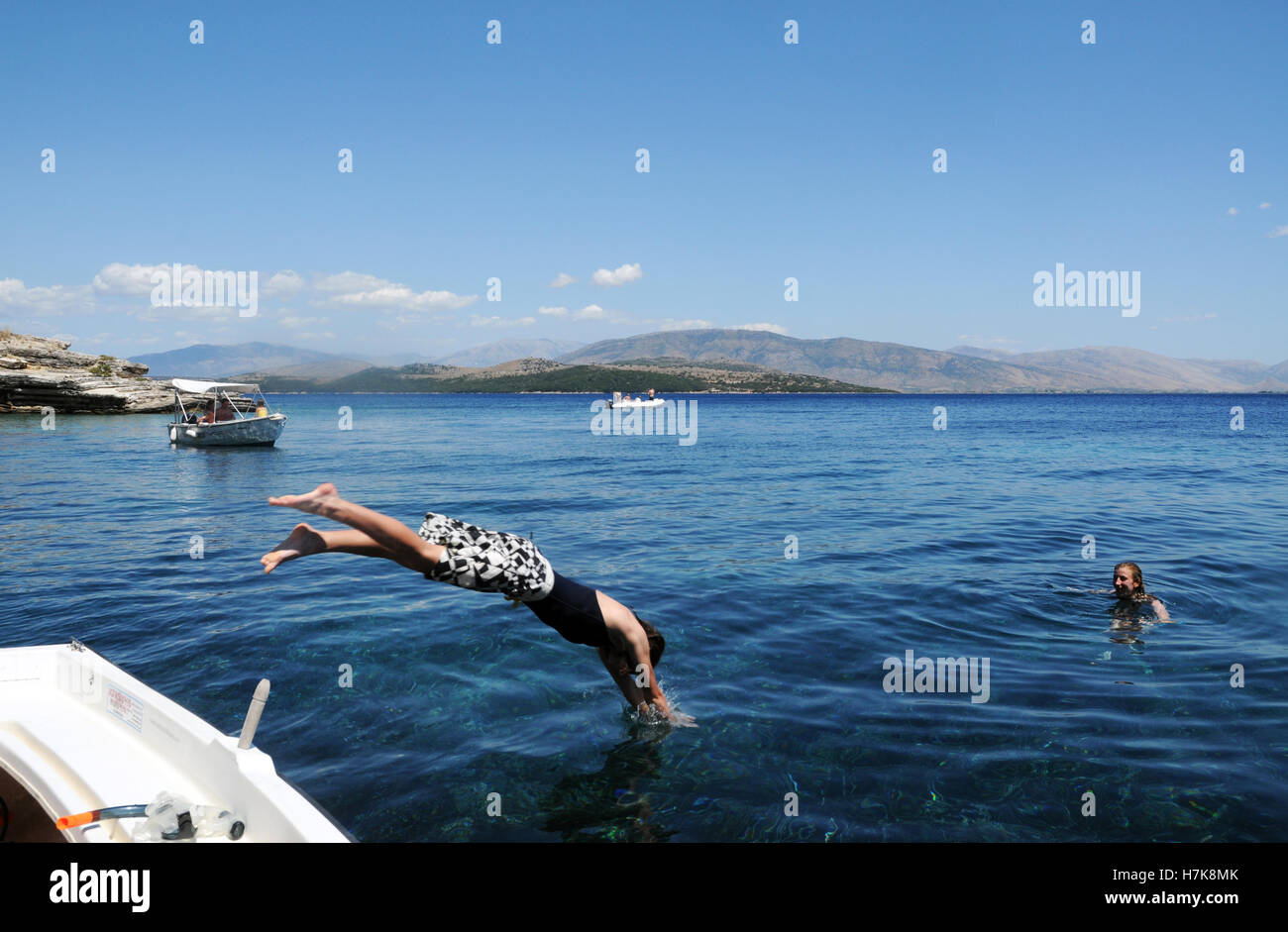 Teenager diving off boat into the sea on holiday in Greece Stock Photo