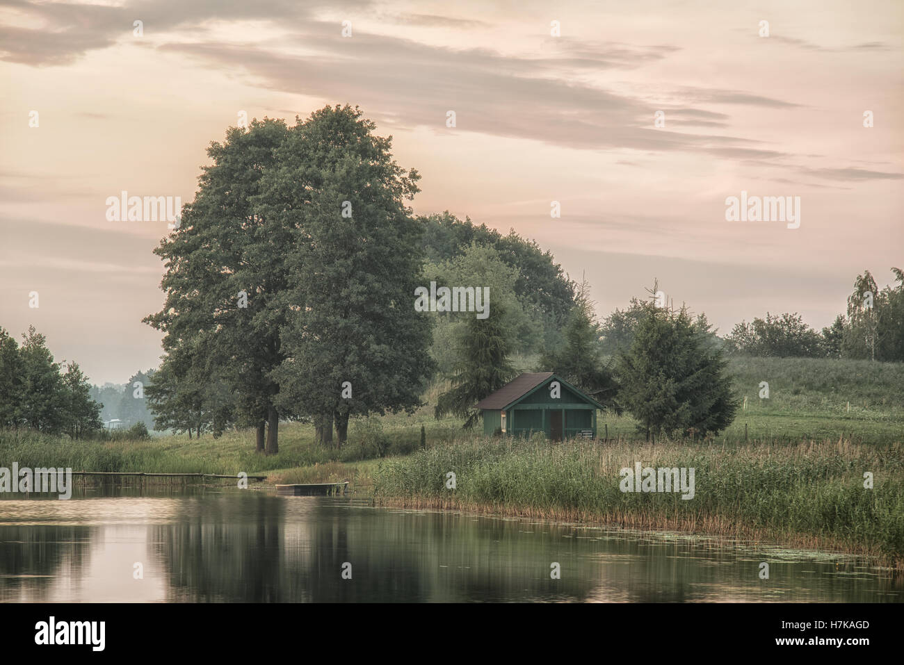 Landscape view and old shed, small bridge and trees by the lake Stock Photo