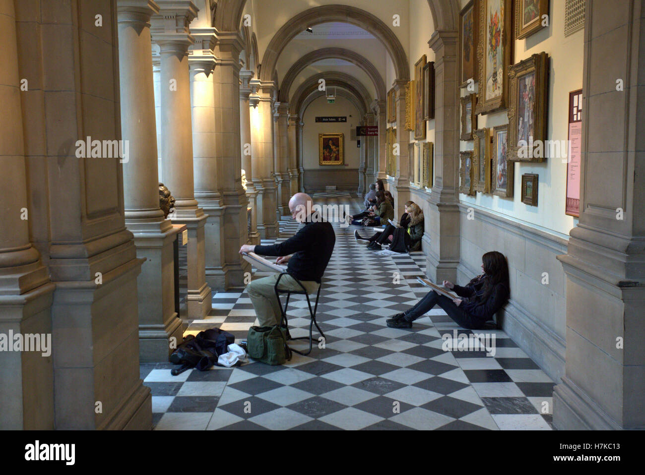 art students drawing in the museum tiled floor kelvingrove art gallery Stock Photo