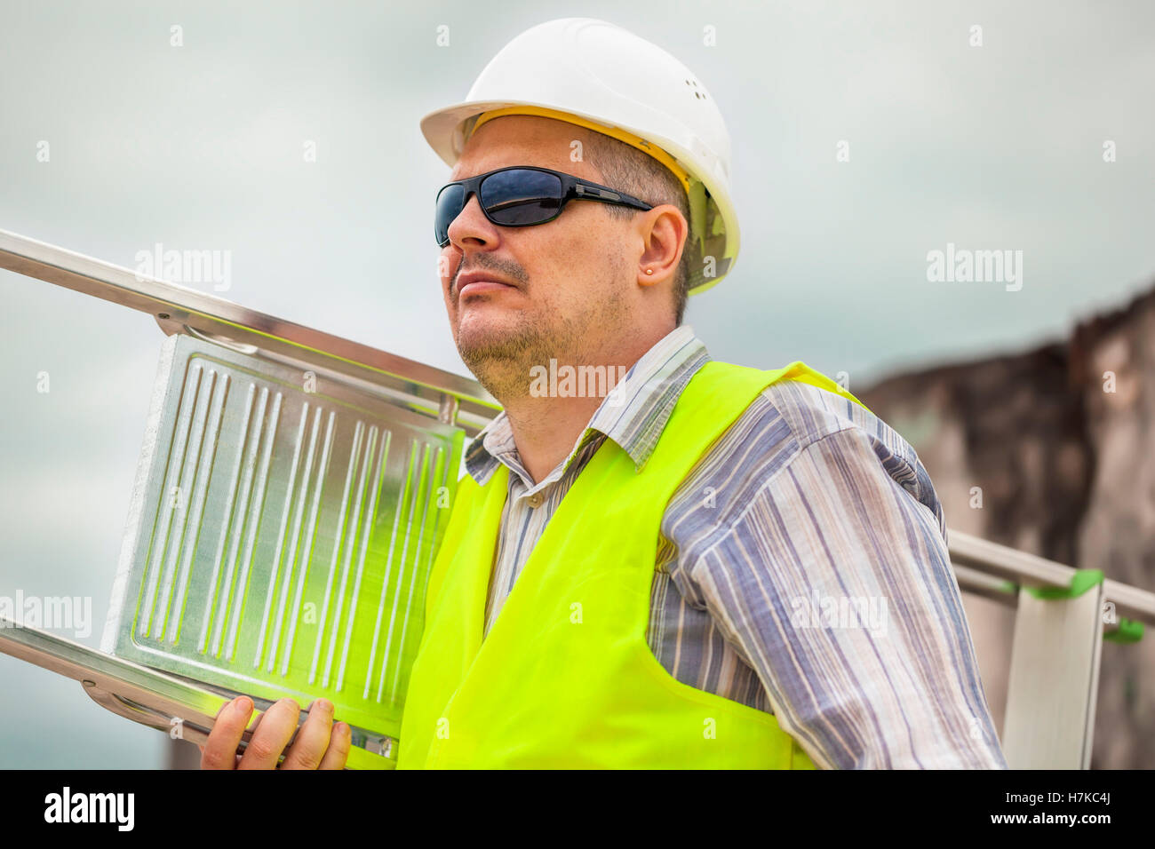Worker with an aluminum ladder Stock Photo