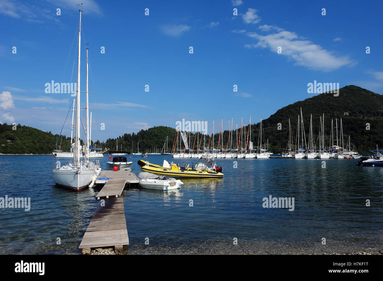 Nidri, GREECE, May 11, 2013: Landscape with blue harbour, green coast, mountains and yachts in Ionian sea, Greece. Stock Photo