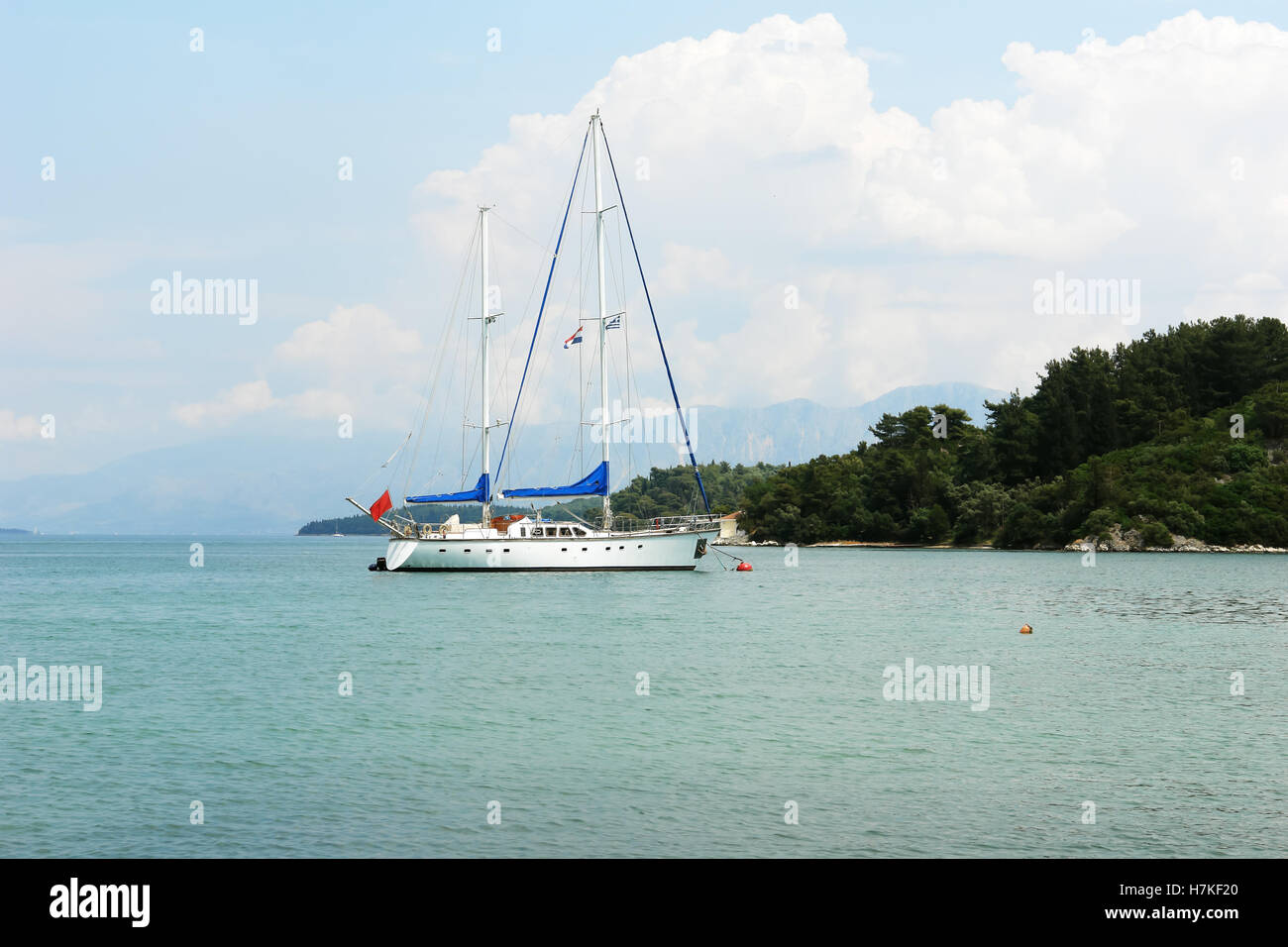 Nidri, GREECE, May 11, 2013: Landscape with green island, mountains and yacht in Ionian sea, Greece. Stock Photo