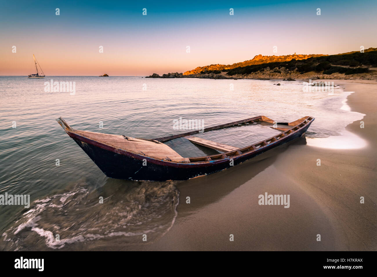 Old wooden boat wrecked on a sandy beach. Stock Photo