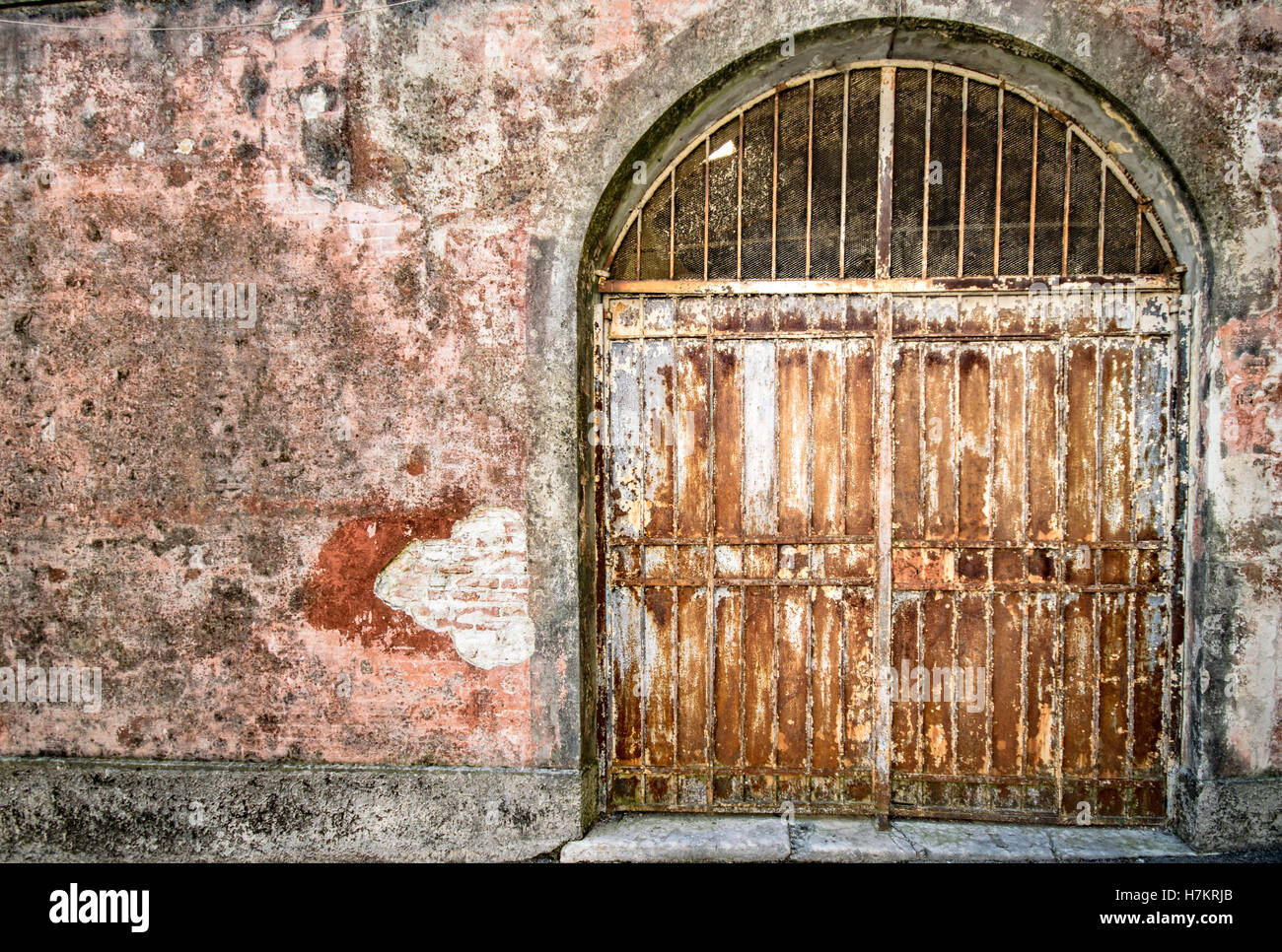Old locked iron gate covered with rust. Stock Photo