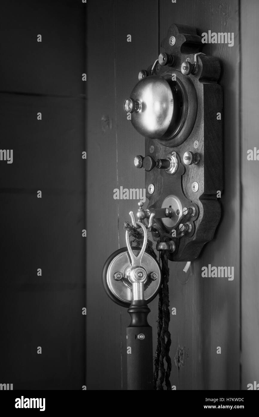 Vintage telephone hanging on the wall Black and White Stock Photos