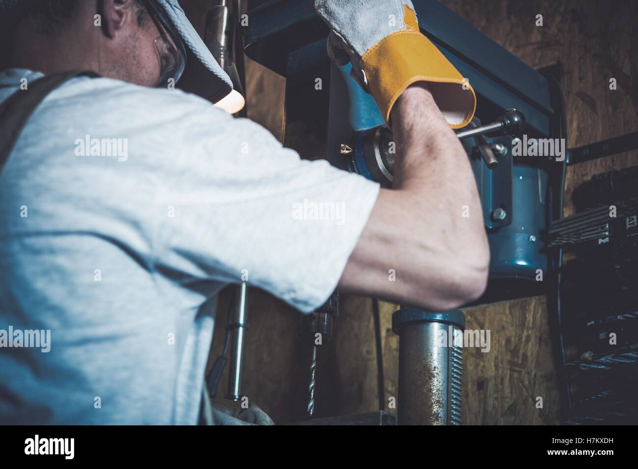 Garage Metal Works. Men and the Professional Grade Driller in His Garage. Stock Photo