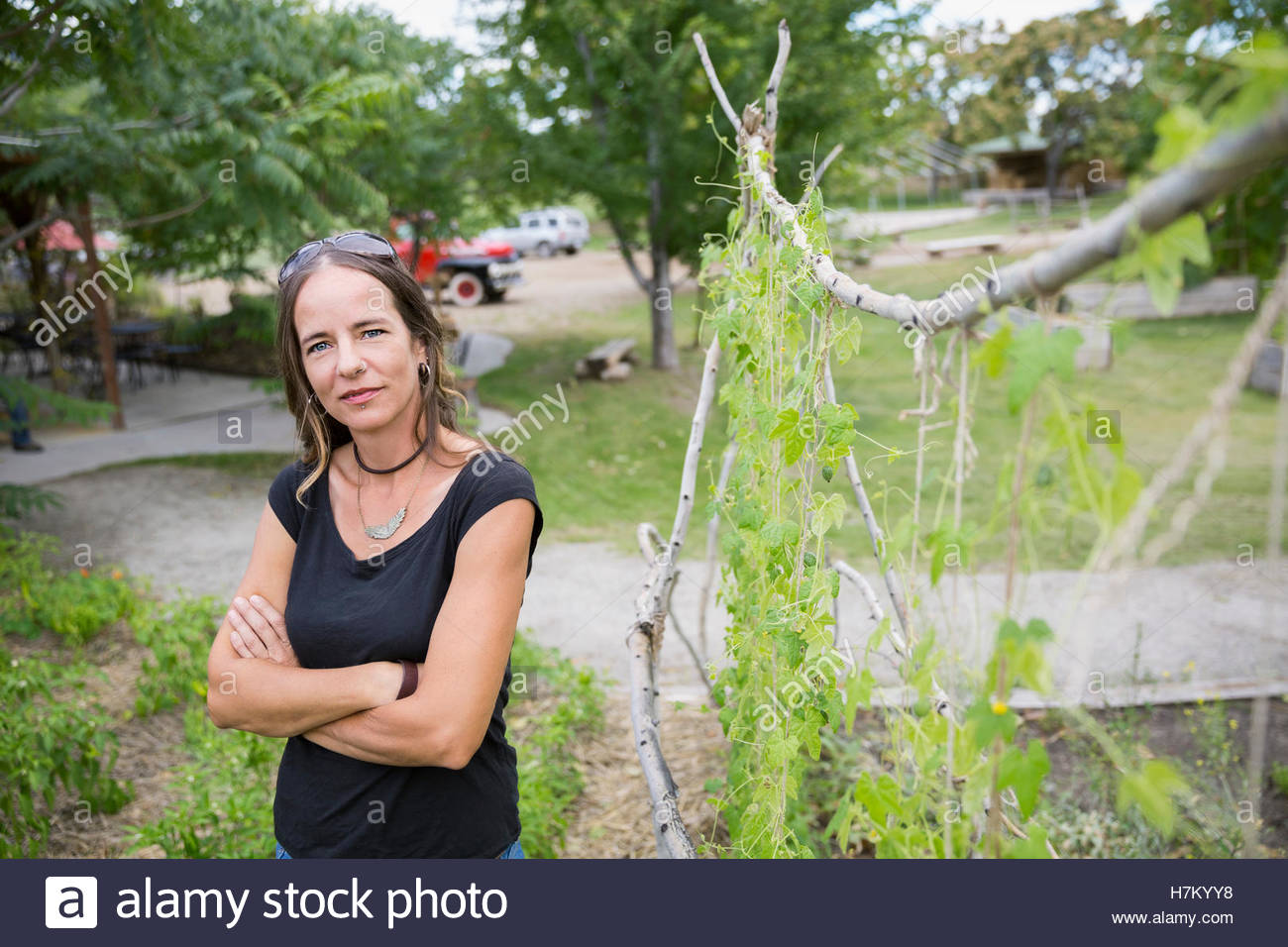 Portrait confident woman with arms crossed in vegetable garden Stock Photo