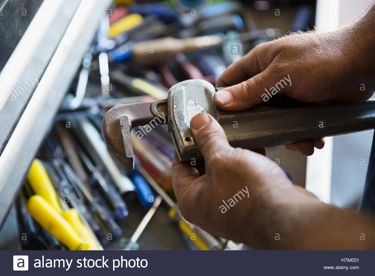 Close up male mechanic adjusting monkey wrench Stock Photo