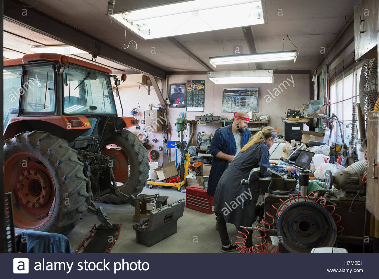 Mechanics working at laptop near tractor in Stock Photo Alamy