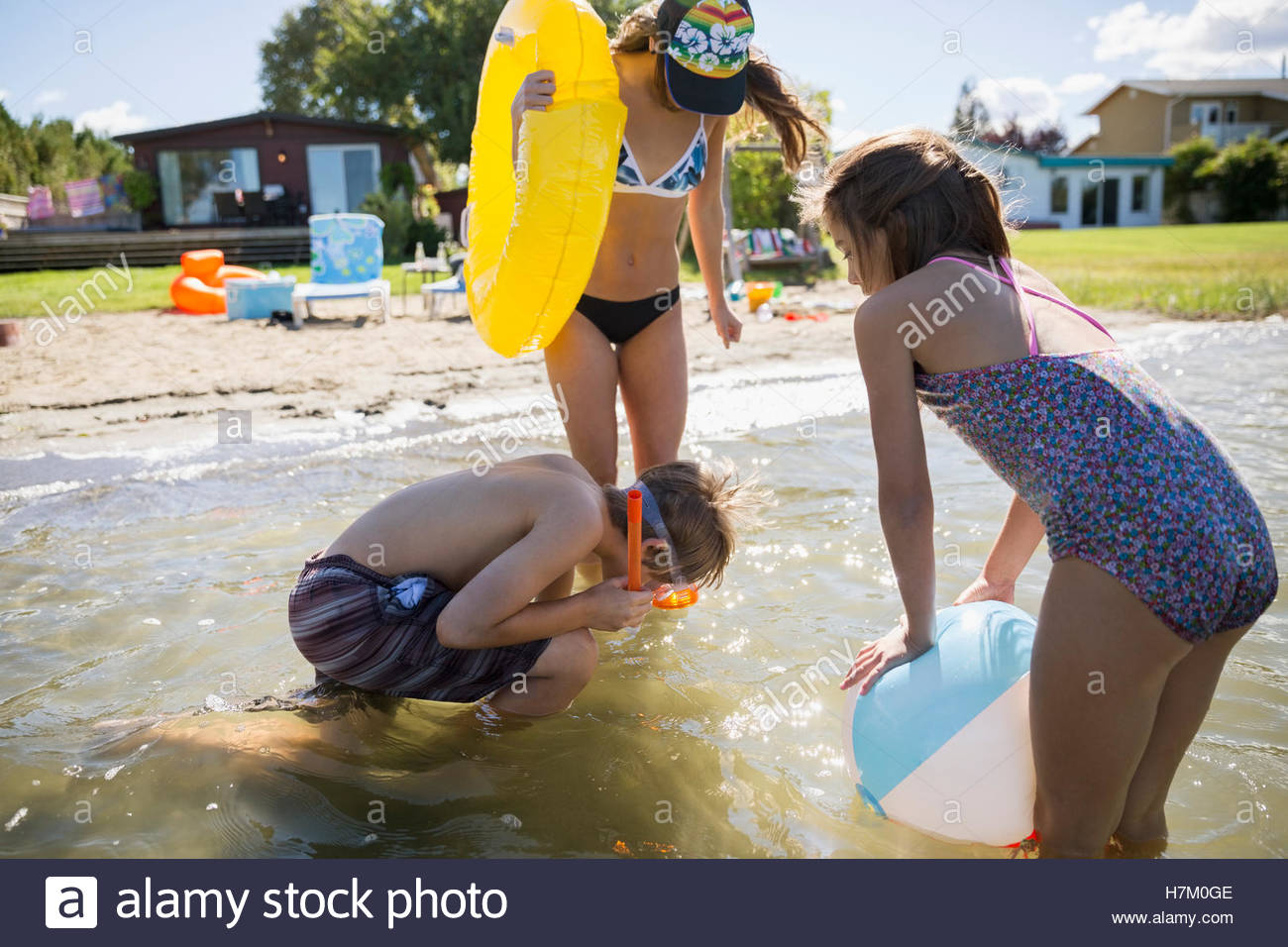 Brother and sisters playing in sunny summer lake Stock Photo