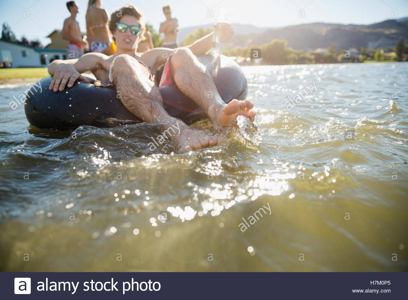 Young man floating in inner tube at sunny summer lake Stock Photo Alamy