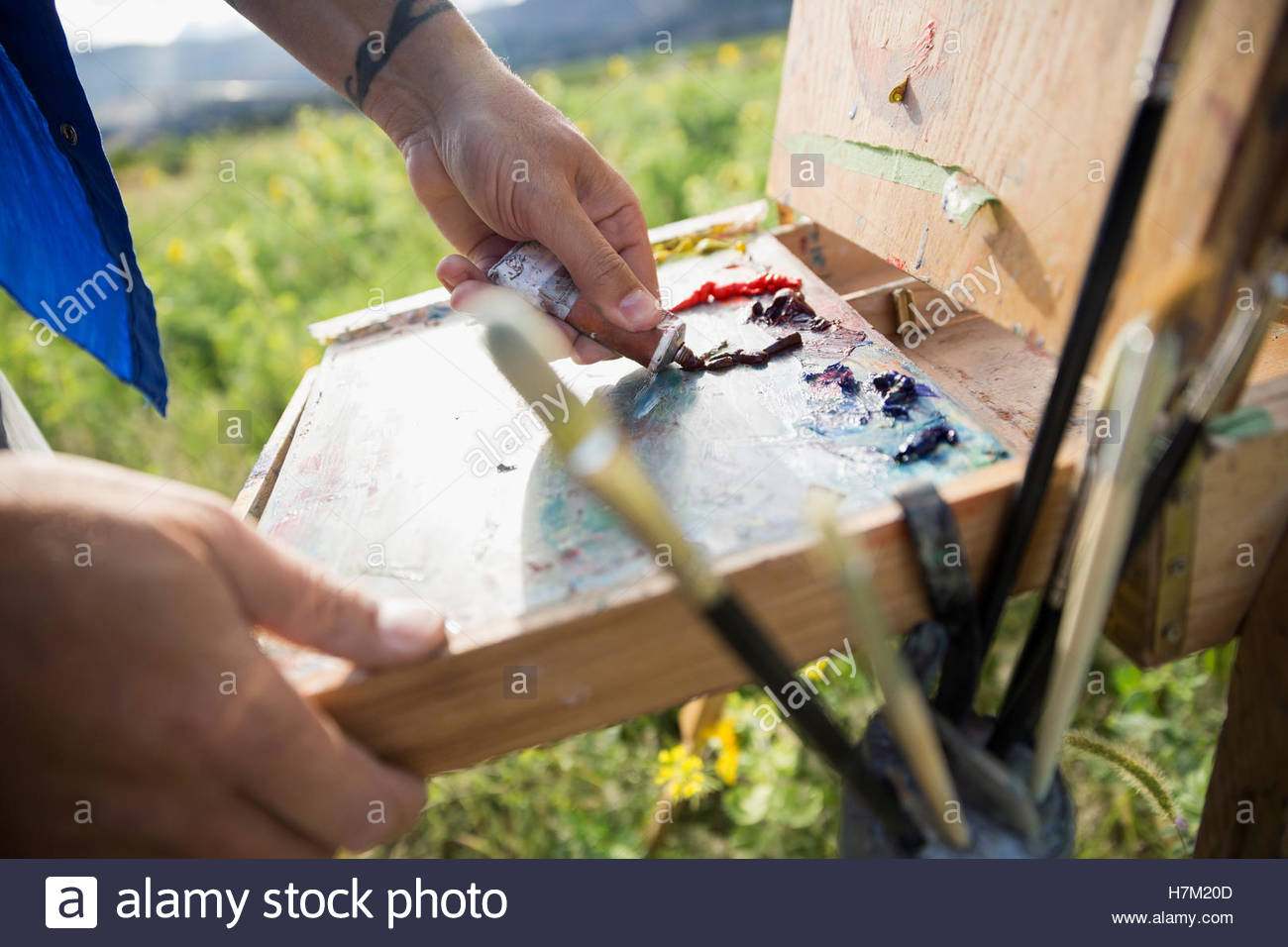 Male painter squeezing paint onto palette Stock Photo