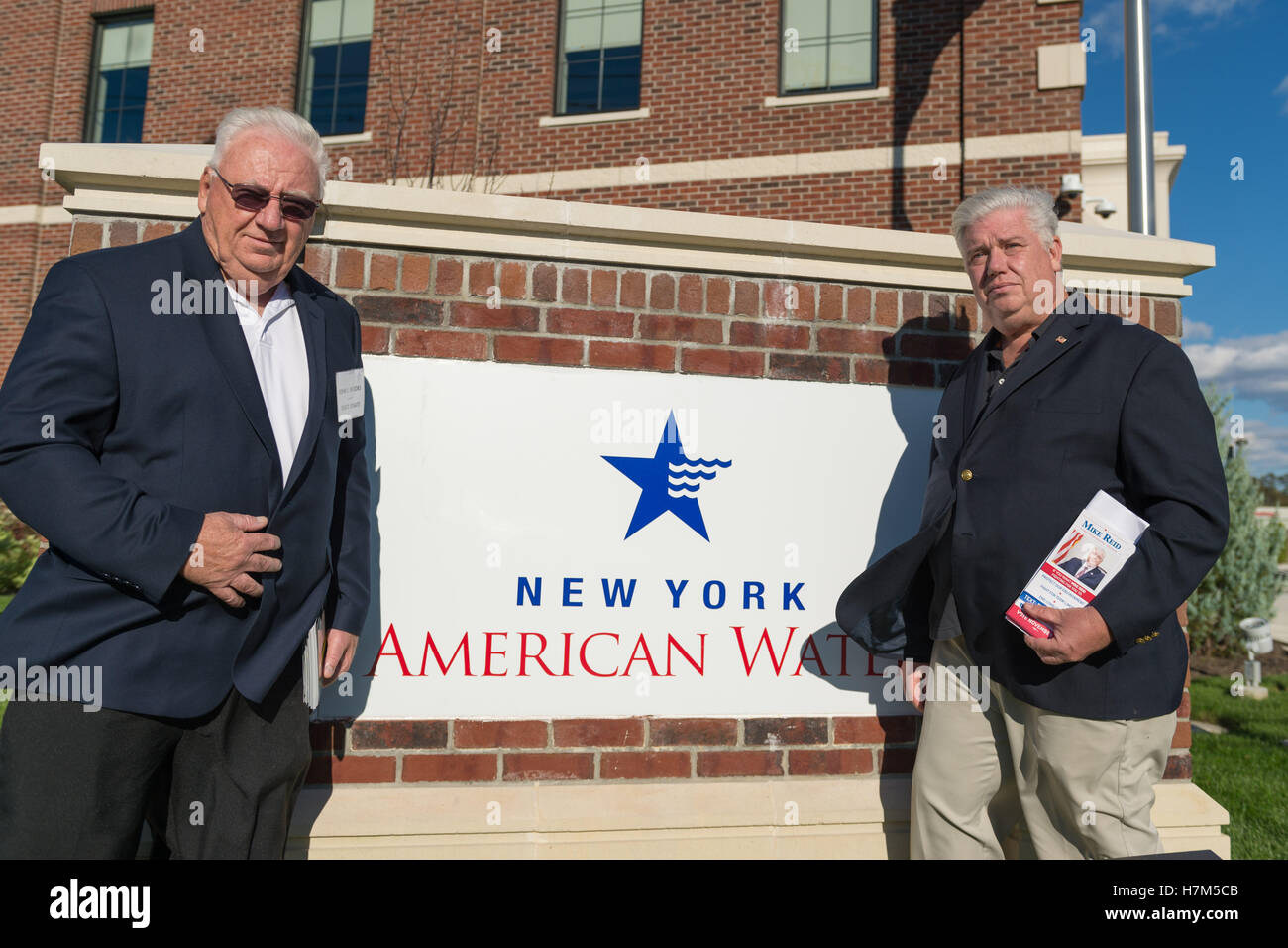 October 23, 2016 - Merrick, New York, United States - L-R, JOHN E. BROOKS, Democratic Party candidate for New York State Assembly District 14, and MIKE REID, Democratic Party Candidate for New York Legislature, attend environmental and civic groups' rally to demand public water and protest New York American Water's (''NYAW'') proposal to raise residents' water bills by 9.90%. Candidates are posing next to company sign outside the New York American Water Headquarters. (Credit Image: © Ann Parry via ZUMA Wire) Stock Photo