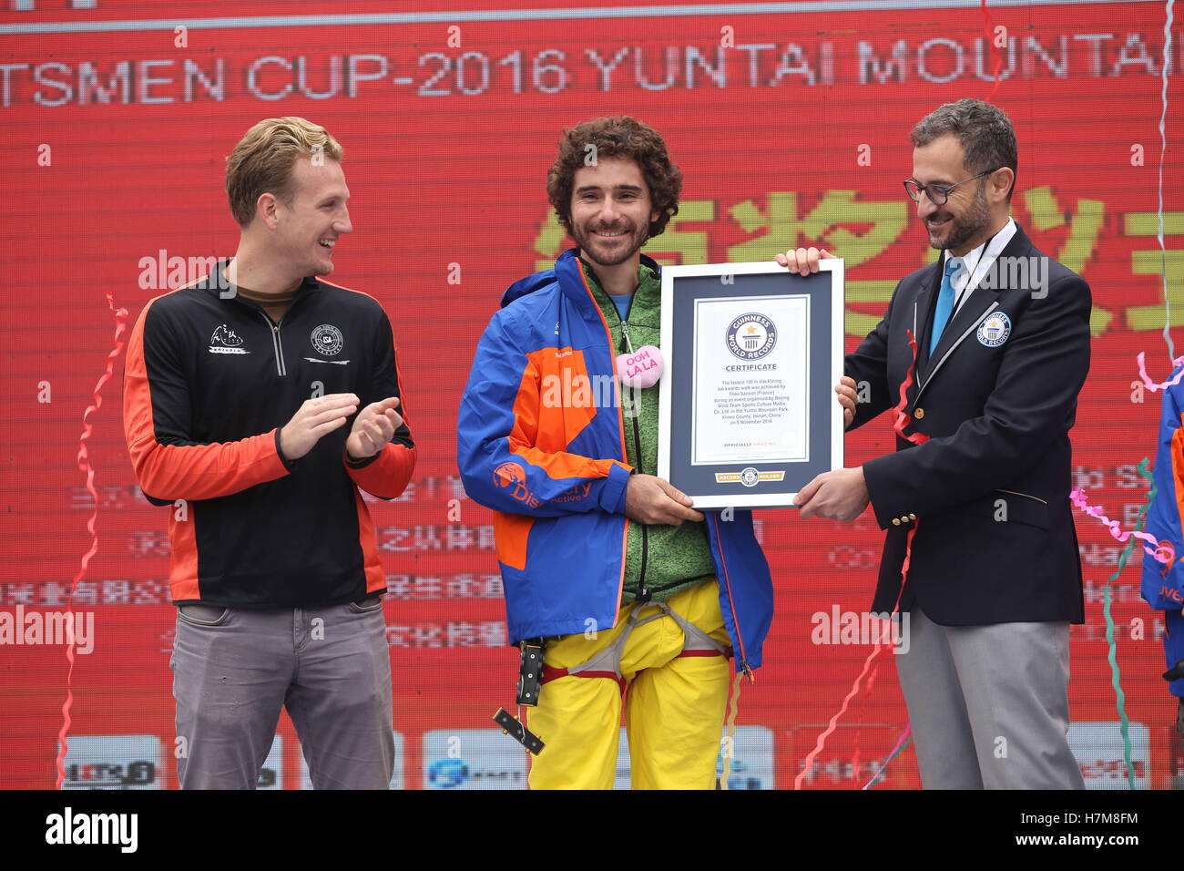 Jiaozuo, China. 6th Nov, 2016.  Jim Daniel Sanson, a 29-year-old slackline walker from France, receives the award after he breaks the Guinness World Record of slackline backward walking in Yuntai Mountain in Jiaozuo, central China's Henan Province, November 6th, 2016. The Guinness World Records Challenge Competition of Backward Walking on Slackline was held in Yuntai Mountain, Jiaozuo, Henan Province on November 6th, 2016. Credit:  ZUMA Press, Inc./Alamy Live News Stock Photo
