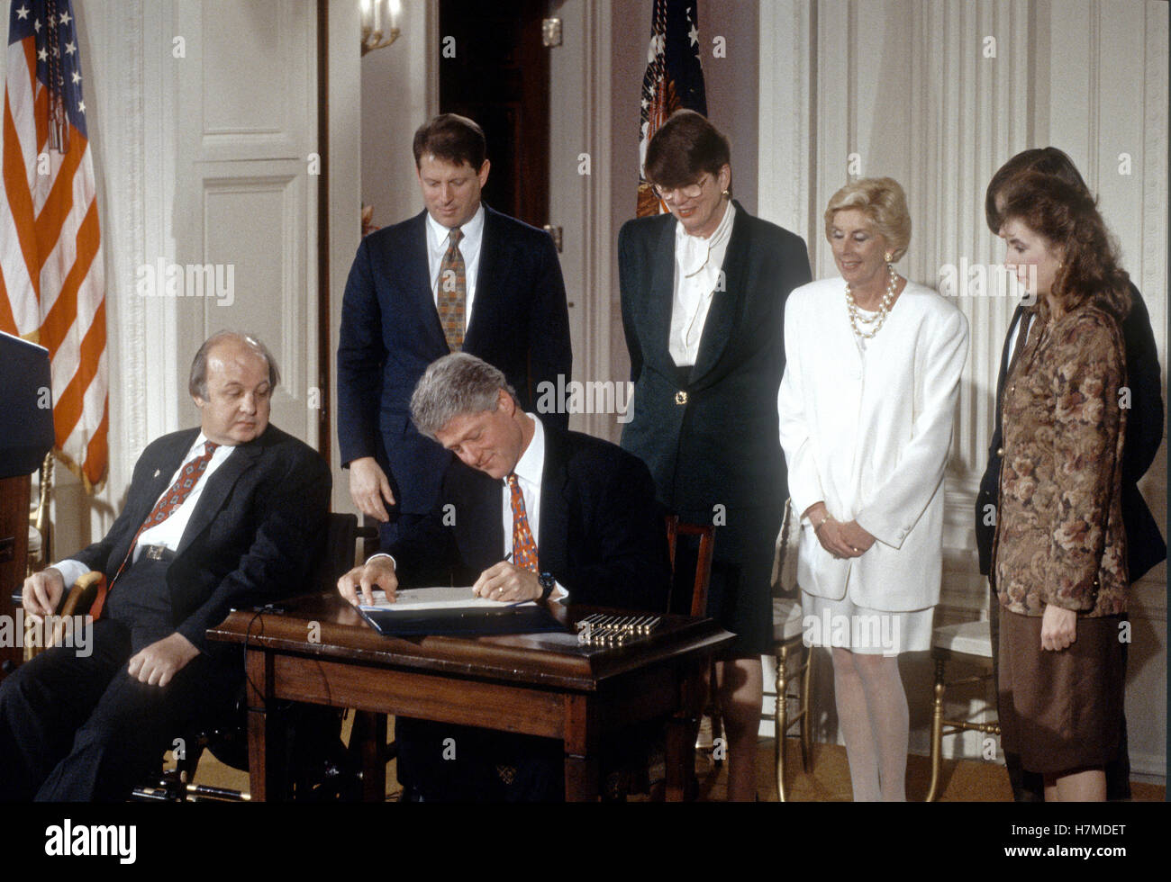 United States President Bill Clinton signs the 'Brady Bill' during a ceremony in the East Room of the White House in Washington, DC on November 30, 1993. From left to right: Former White House press secretary James S. Brady; U.S. Vice President Al Gore; President Clinton; U.S. Attorney General Janet Reno; Sarah Brady, wife of James Brady; and Melanie Musick, whose husband was killed by a hand gun. Brady passed away on Monday, August 4, 2014. Credit: Ron Sachs/CNP /MediaPunch Stock Photo
