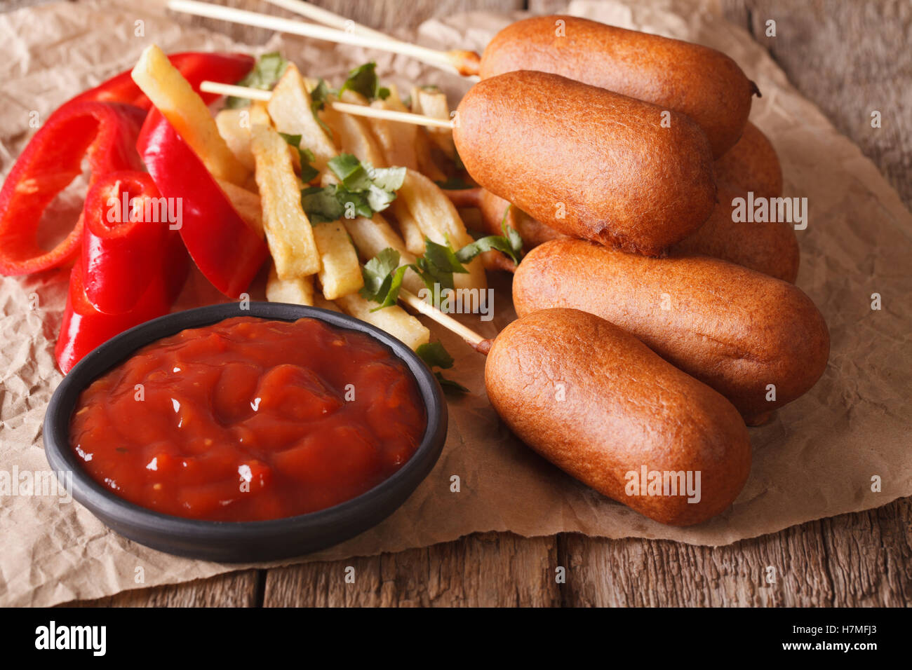 Corn dogs, french fries, pepper and ketchup on the table close-up. horizontal Stock Photo