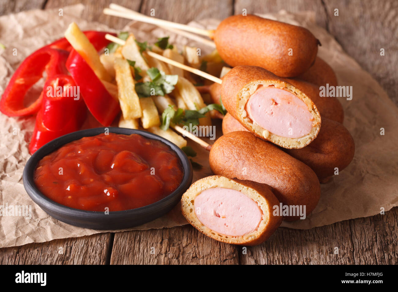 Fast food: corn dog, french fries and ketchup on the table close-up. horizontal Stock Photo