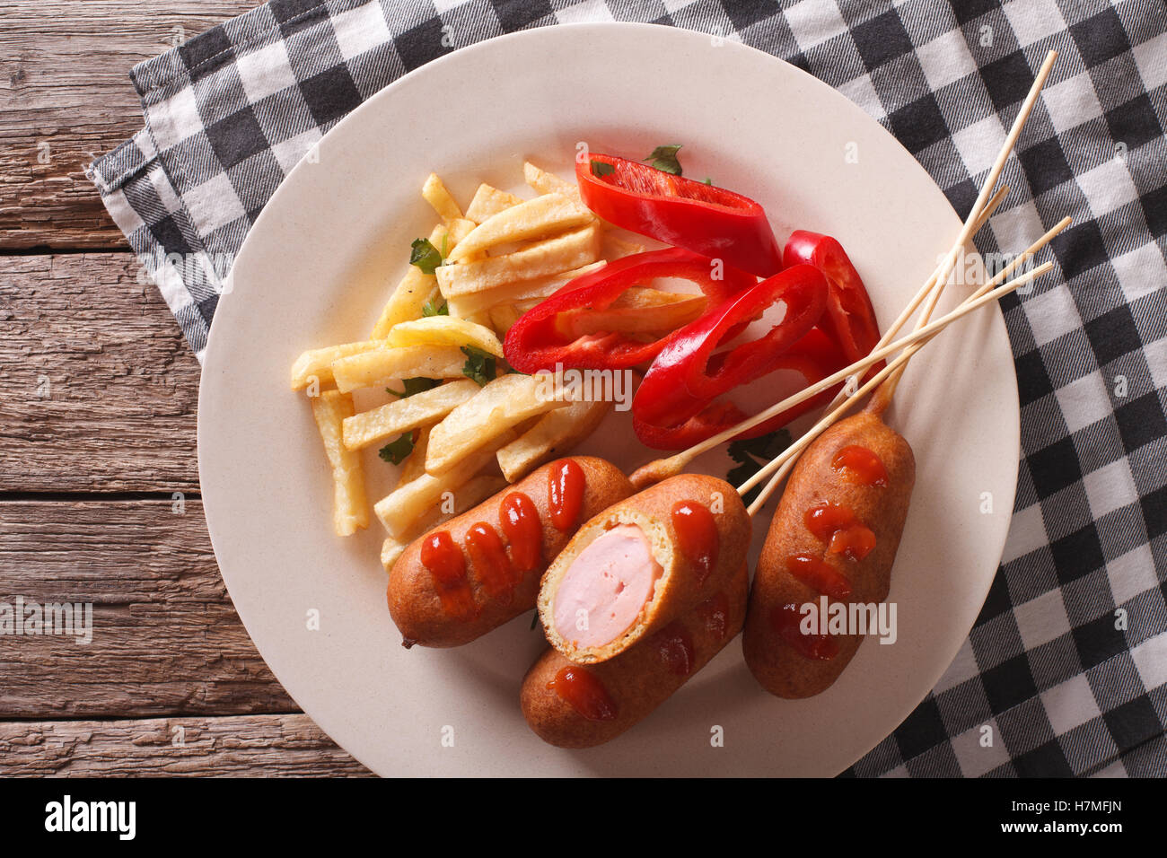 Fast food: corn dog and fries on a plate close-up on the table. horizontal view from above Stock Photo