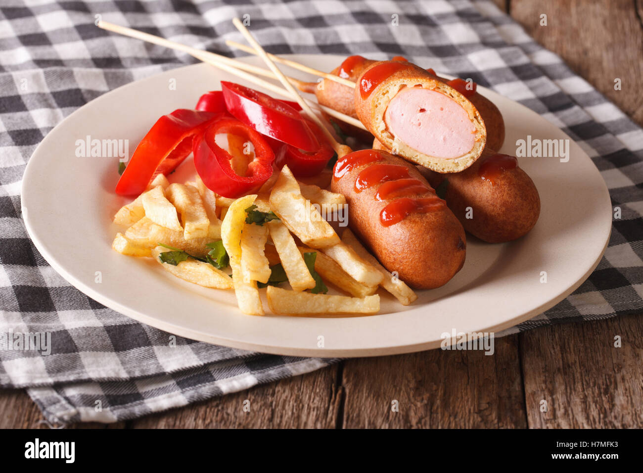 Fast food: corn dog and fries on a plate close-up on the table. horizontal Stock Photo