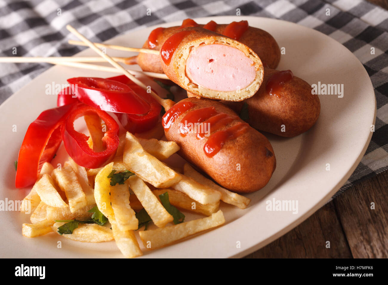 Corn dog, french fries and vegetables on a plate close-up on the table. horizontal Stock Photo