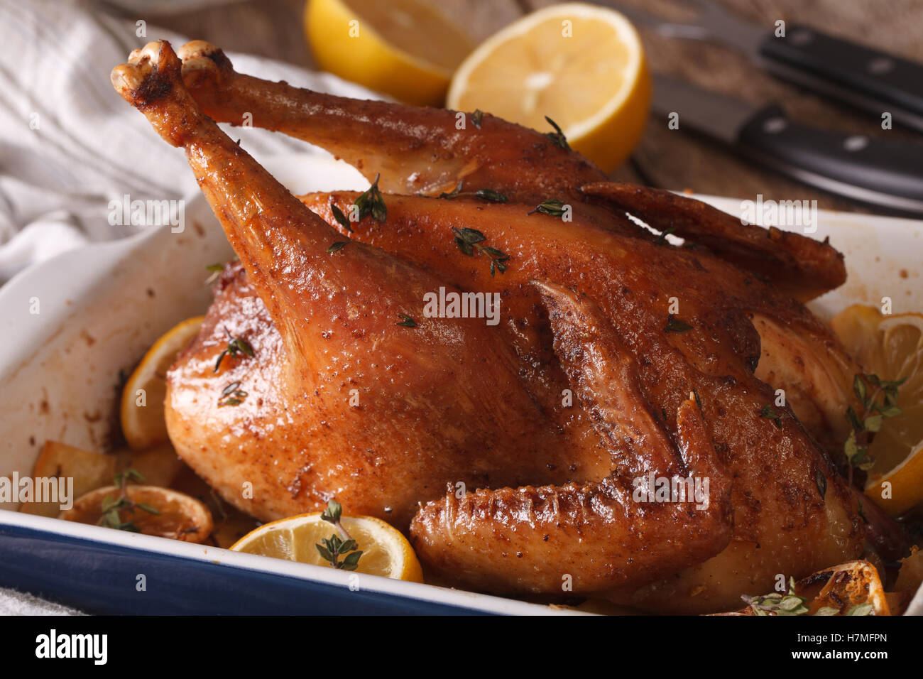 whole chicken with lemon and thyme baked in a baking dish closeup. horizontal Stock Photo