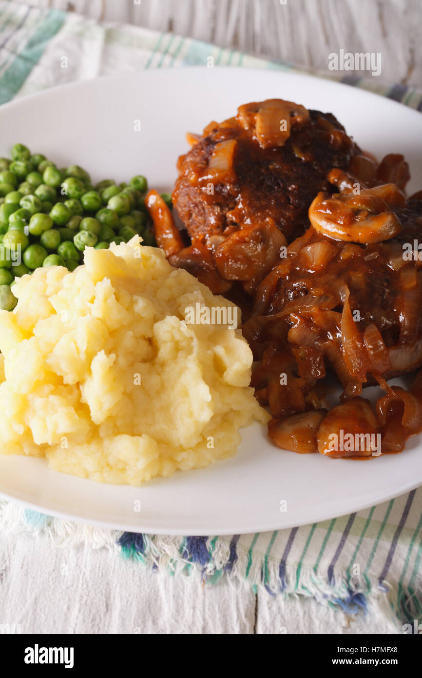 Salisbury steak with mushroom sauce, mashed potatoes and green peas