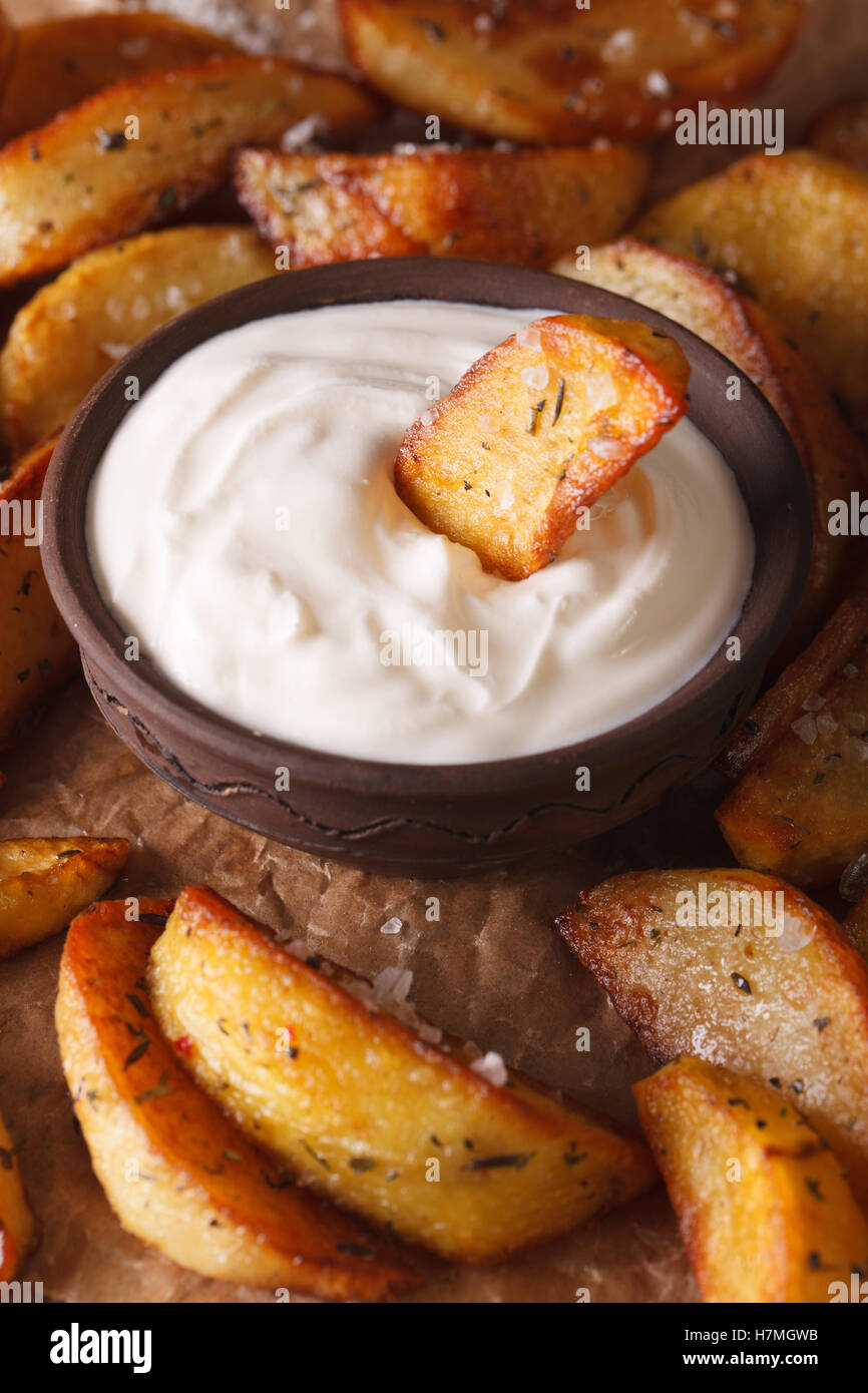 Baked potato wedges and mayonnaise macro on the table. Vertical Stock Photo
