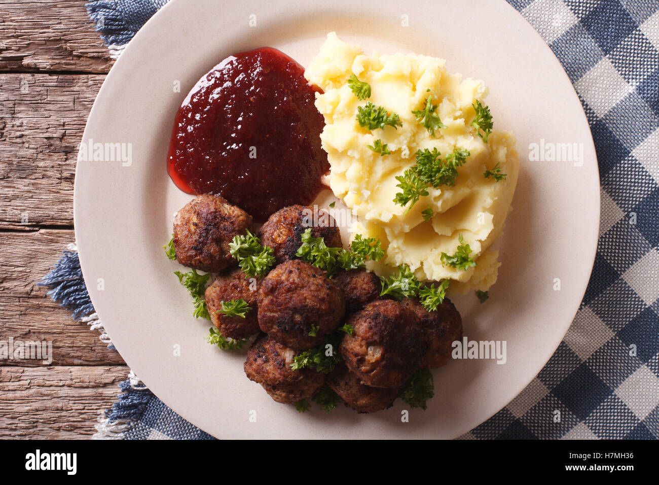 Swedish meatballs kottbullar, lingonberry sauce with a side dish mashed potato on the plate closeup. horizontal view from above Stock Photo