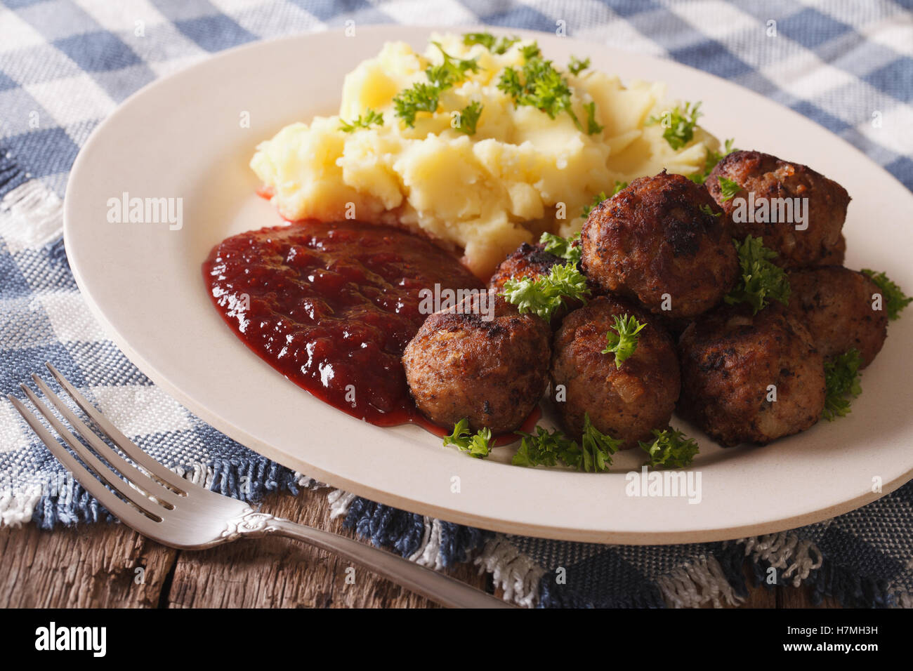 Swedish food meatballs, lingonberry sauce with potato garnish on a