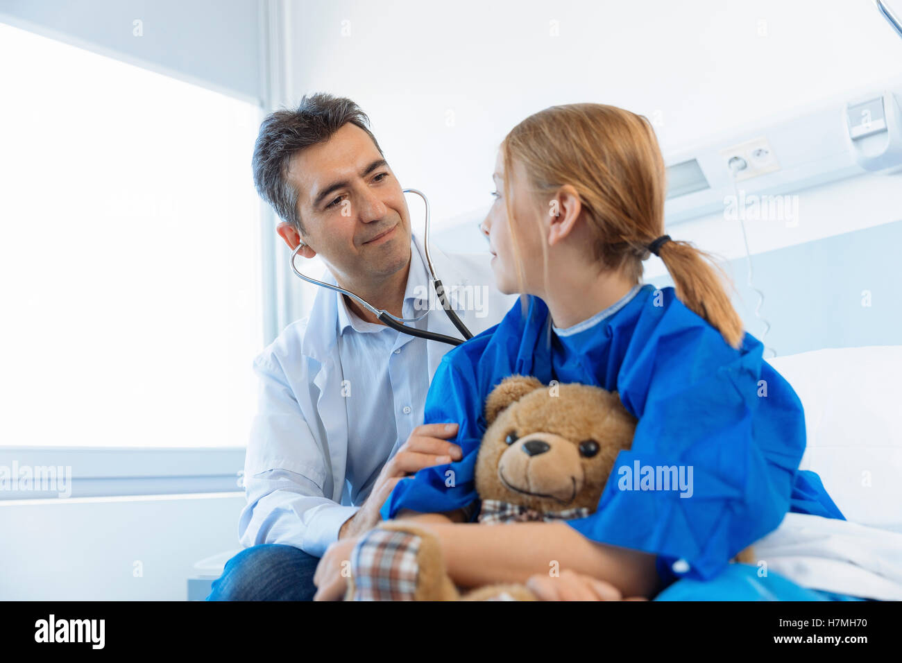 Doctor examining girl patient in hospital Stock Photo