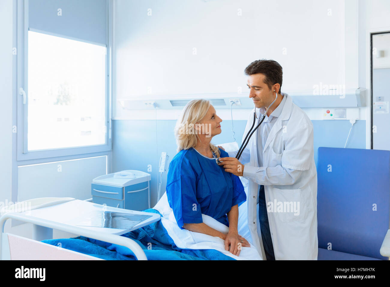 Doctor examining senior patient in hospital Stock Photo