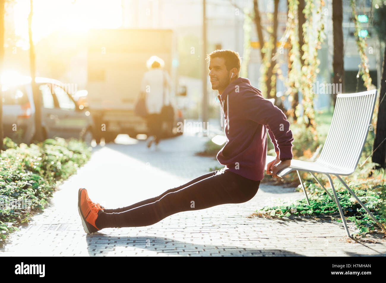 runner doing some triceps dips on a bench Stock Photo