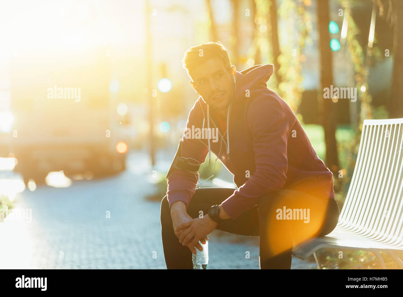 Athlete resting on the bench with bottle of water Stock Photo