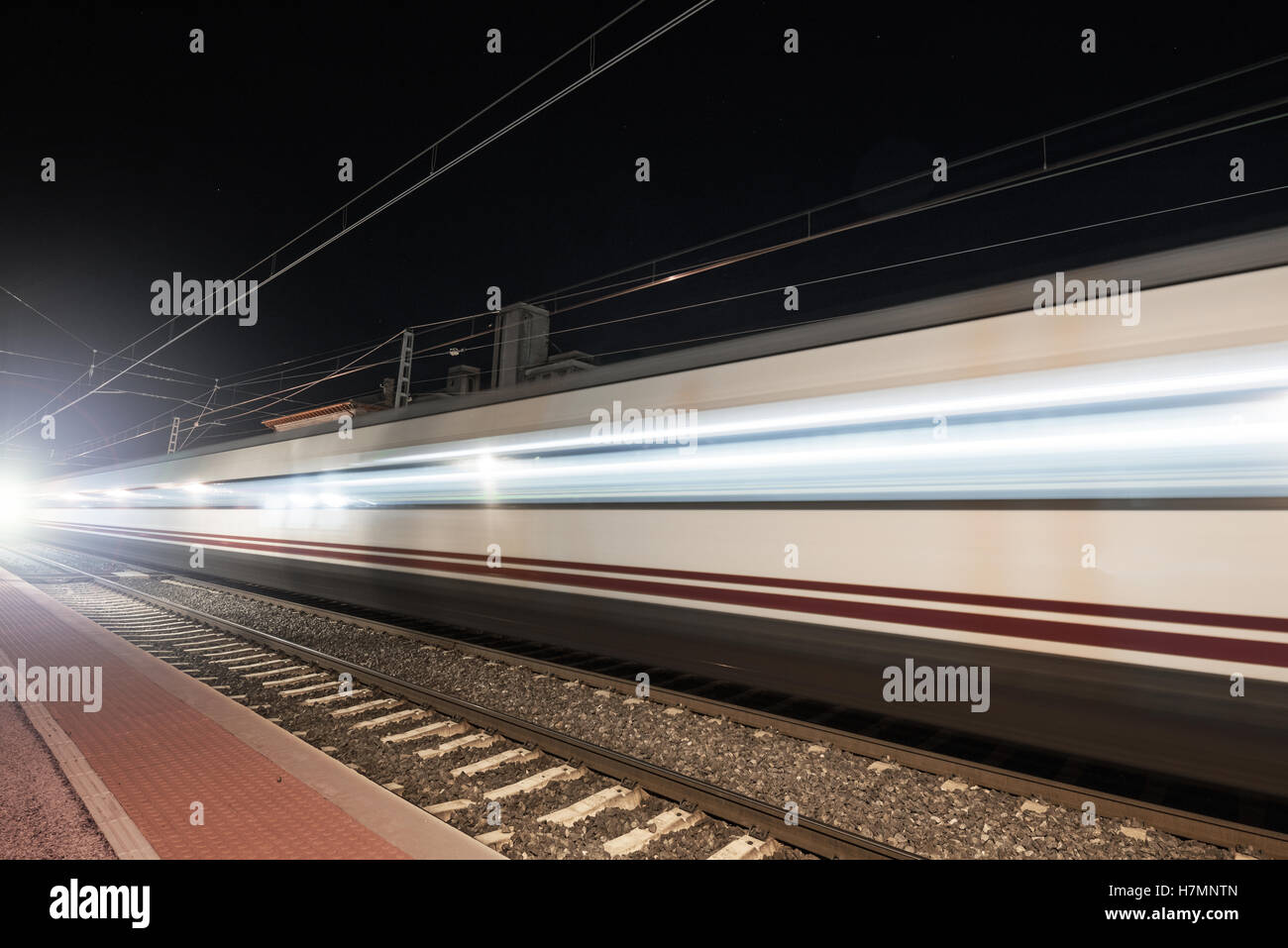 Train Light Effect Fast train passing through a railway station at night (motion blurred ...