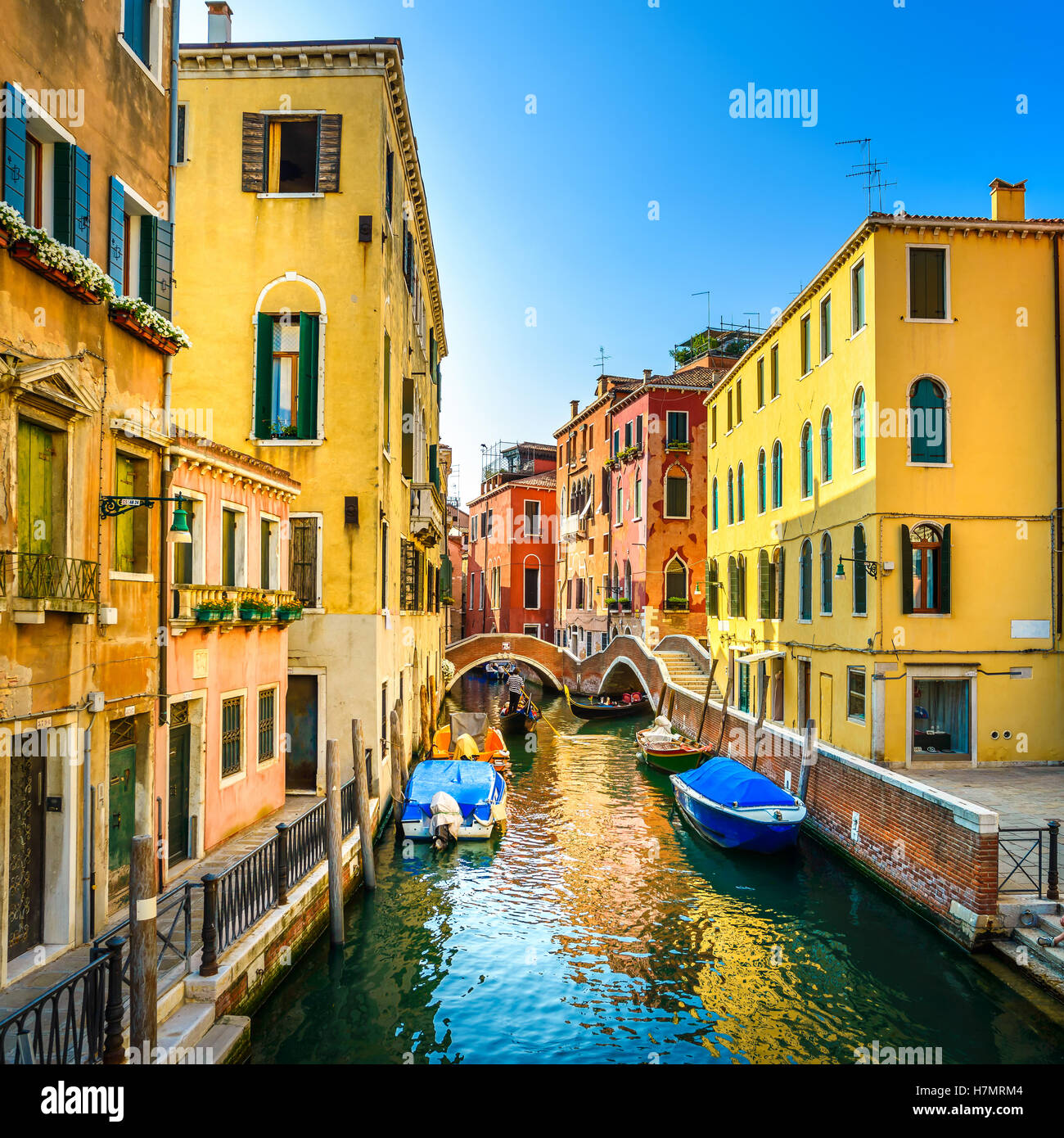 Venice sunset cityscape, boats, water canal, double bridge and traditional buildings. Italy, Europe. Stock Photo