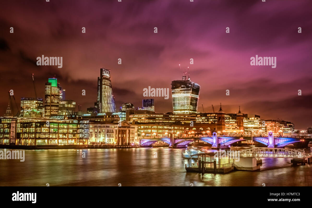 Night skyline of London as seen from the Thames riverbank, England ...