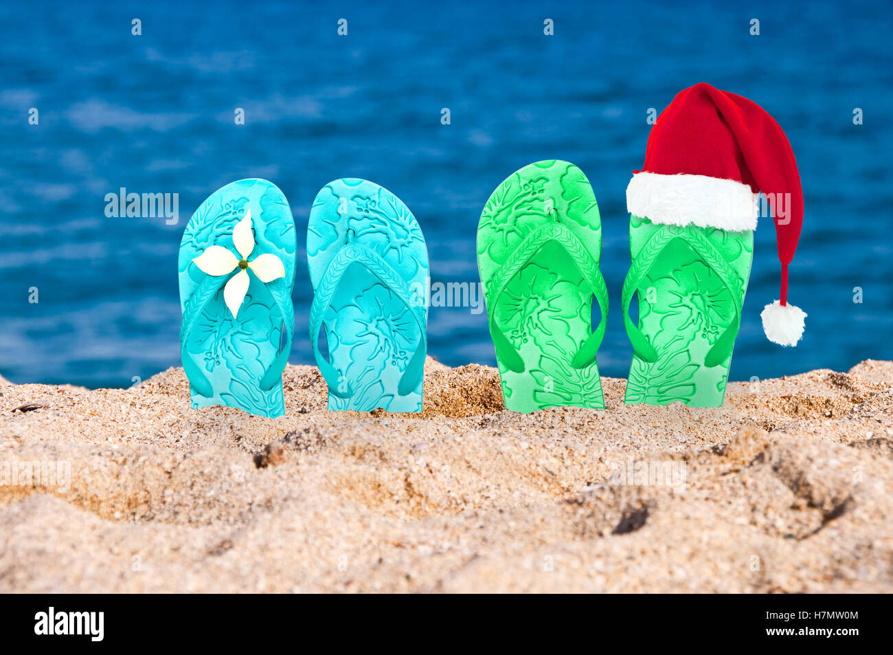 Christmas hat on flip flops in the sand of a beach Stock Photo