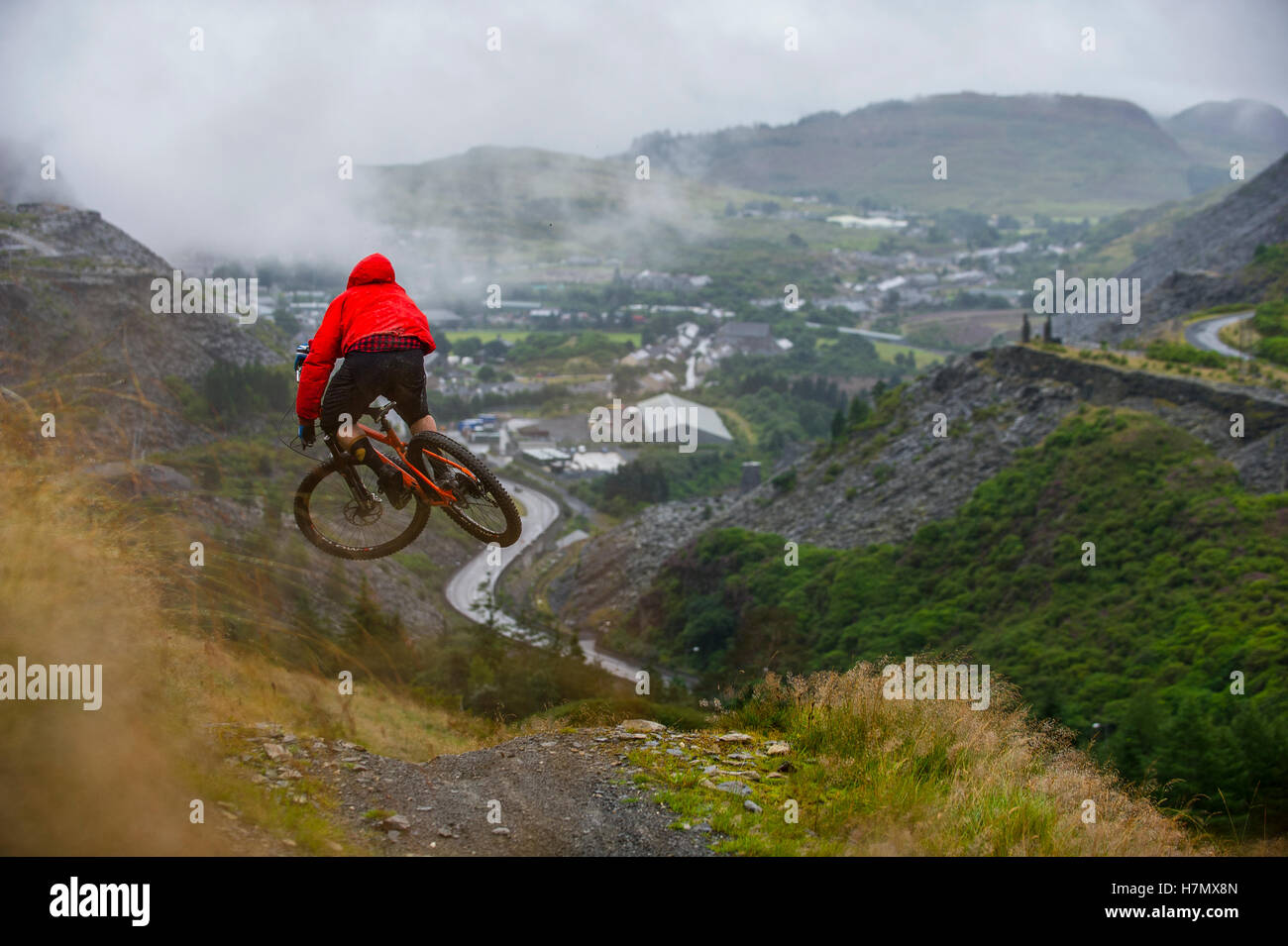 A mountain biker jumps a rock drop at Antur Stiniog mountain bike