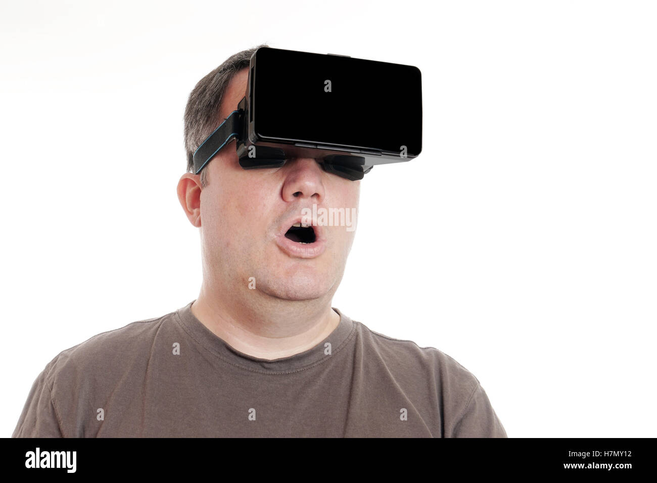middle aged man wearing VR virtual reality headset is stunned Stock Photo