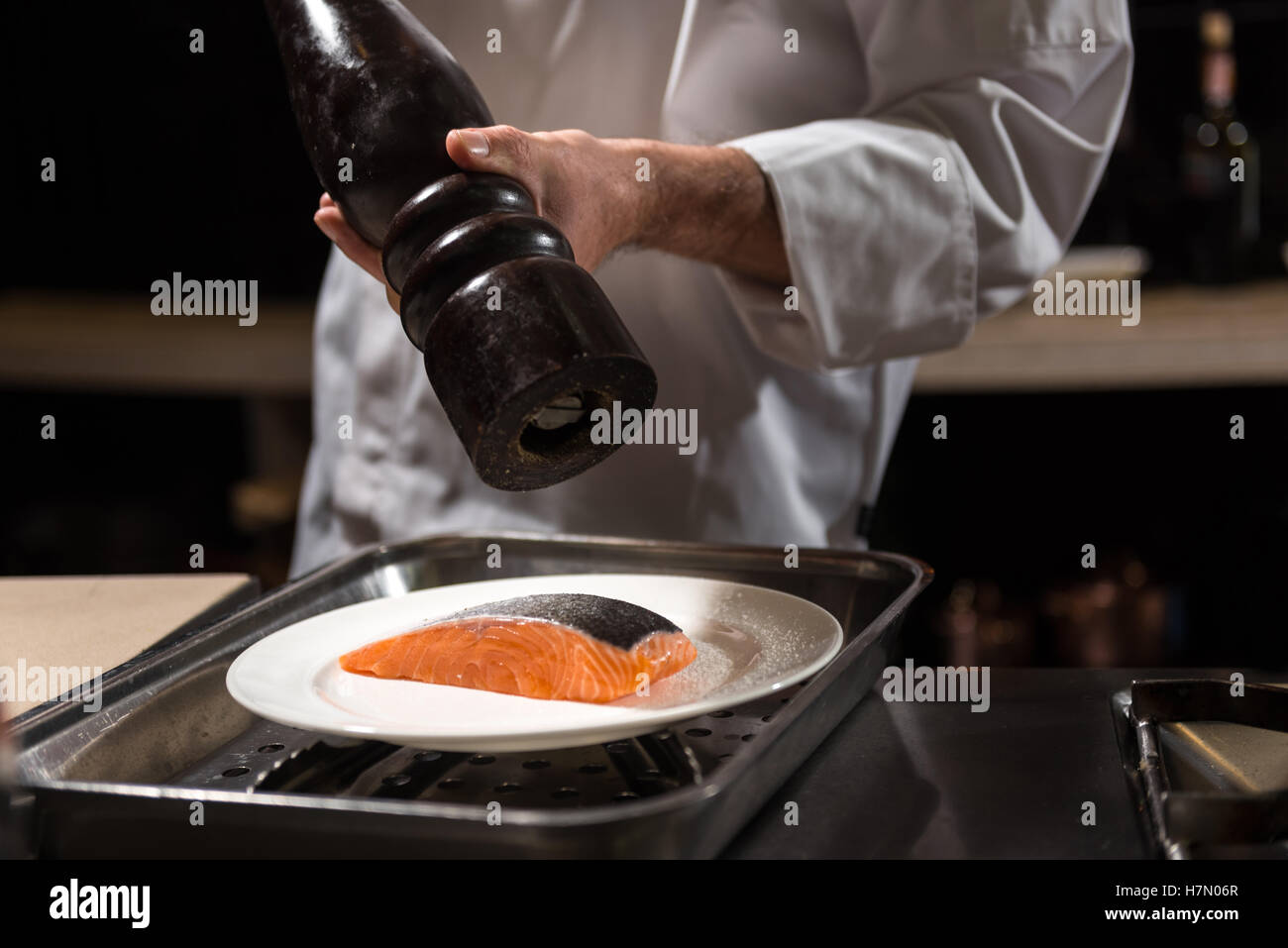 Concentrated chef putting salt on the salmon steak Stock Photo Alamy