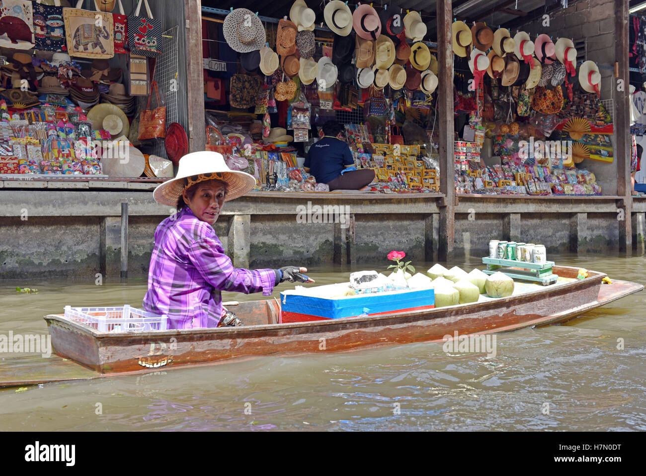 A floating food vendor paddles her canoe selling coconut ice cream at